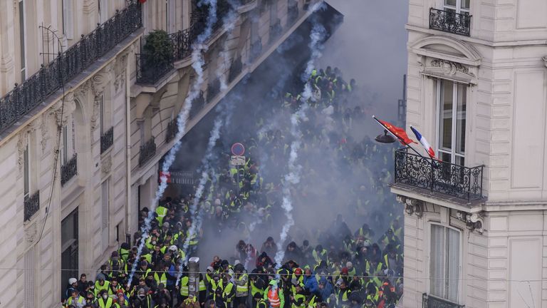 &#39;Yellow vest&#39; protesters clash with riot police amid tear gas on the Champs Elysees in Paris 