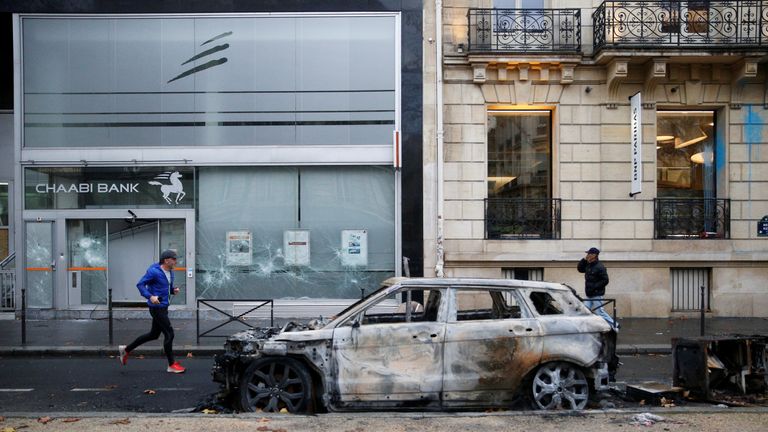 A vandalized car and bank front are seen the morning after clashes with protesters wearing yellow vests, a symbol of a French drivers&#39; protest against higher diesel fuel taxes, in Paris, France, December 2, 2018.
