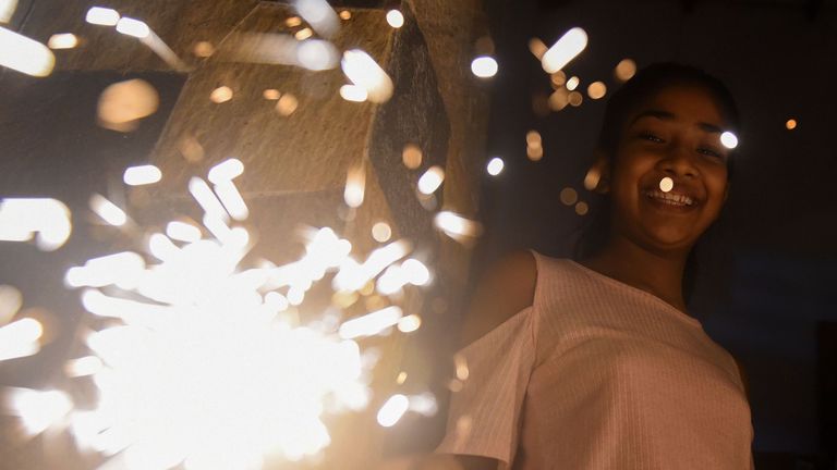 A young woman holds a sparkler during New Year's celebrations in Colombo, Sri Lanka