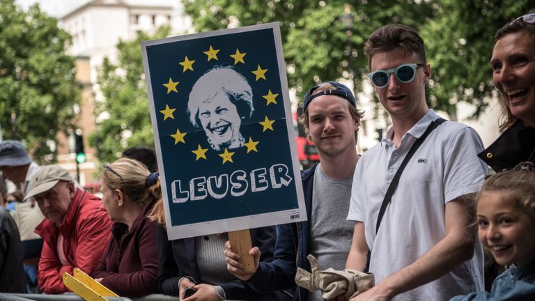 A man holds a placard outside Downing Street following Theresa May's post-election speech 