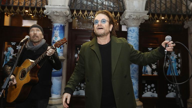 U2&#39;s The Edge and Bono take part in the annual Christmas Eve busk on Grafton Street, Dublin
