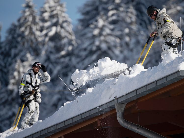 German Bundeswehr soldiers remove snow from the roof of the Watzmann Therme on January 11, 2019 in Berchtesgaden, Germany