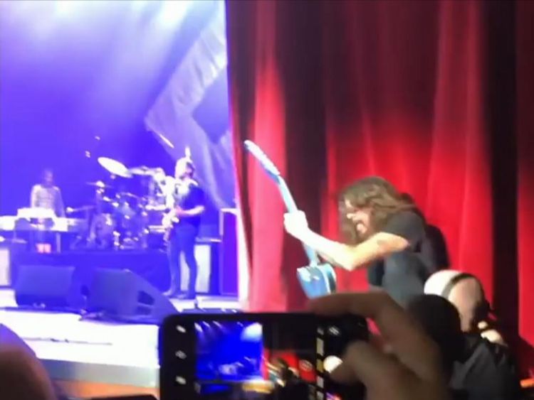 Security guards help Dave Grohl get back on stage. Pic: Instagram/i_play_with_cars