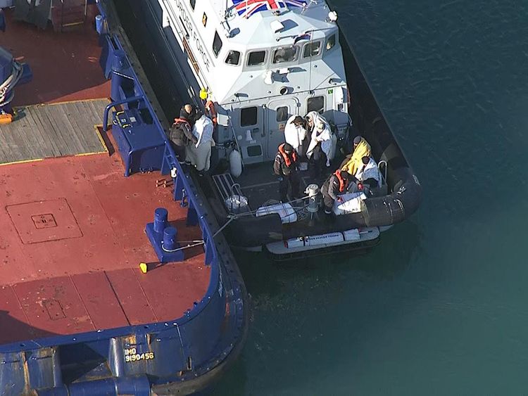 The suspected migrants were wrapped in blankets after disembarking their dinghy