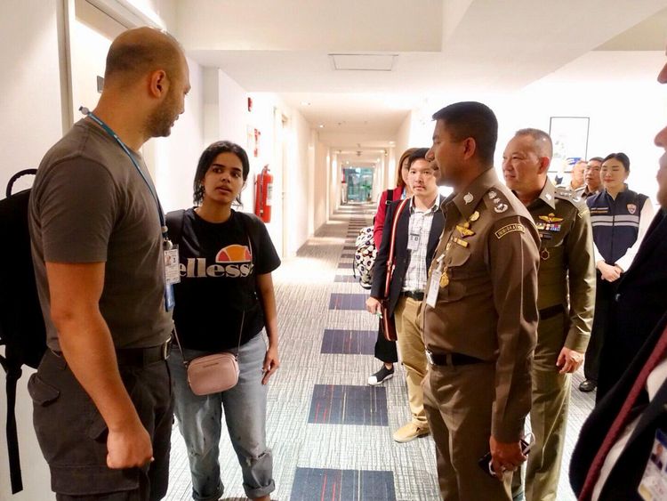 Saudi teen Rahaf Mohammed al-Qunun is greeted by Thai immigration authorities at a hotel inside Suvarnabhumi Airport in Bangkok