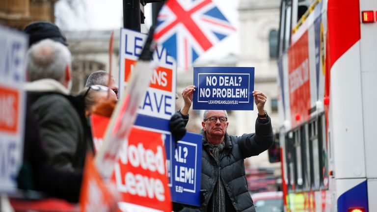 Pro-Brexit demonstrators hold signs outside the Houses of Parliament