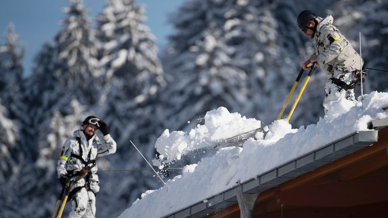 German Bundeswehr soldiers remove snow from the roof of the Watzmann Therme on January 11, 2019 in Berchtesgaden, Germany