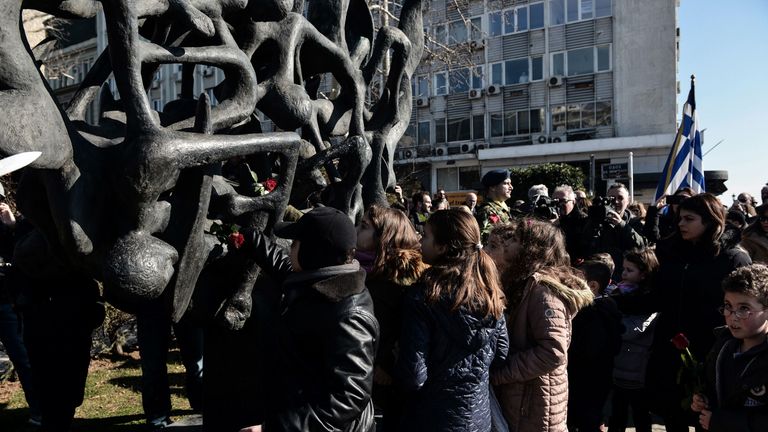 Children lay roses at the Holocaust Memorial in Thessaloniki in Greece