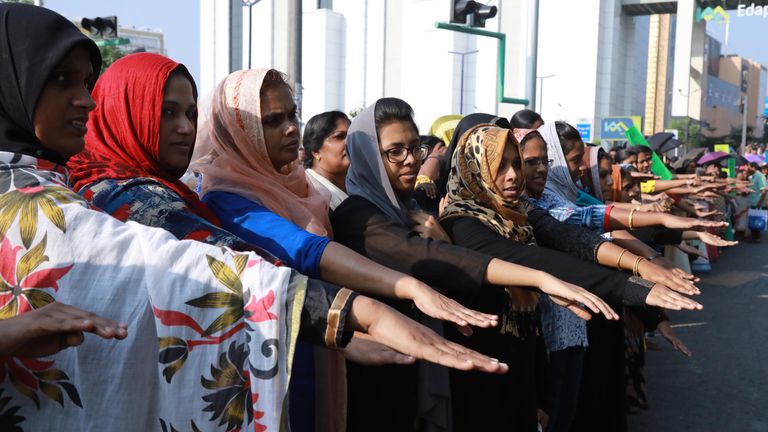 Indian women hold out their hands as they stand in a line to take part in a &#39;women&#39;s wall&#39; protest in Kochi in southern Kerala state on January 1, 2019. - Tens of thousands of women formed a human chain across a southern Indian state on January 1, in support of a court order overturning a partial ban on women entering one of Hinduism&#39;s holiest temples, witnesses said.