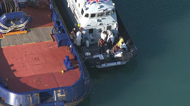 The suspected migrants were wrapped in blankets after disembarking their dinghy