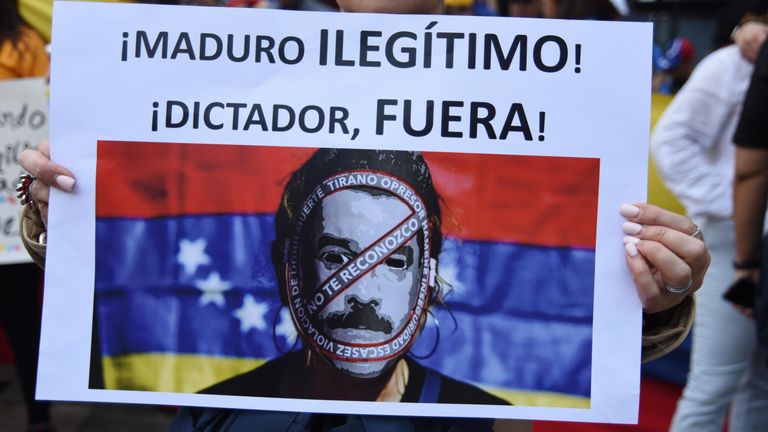 A protester carries a sign reading &#39;Maduro, illegitimate, dictator get out!&#39; in Guatemala, outside the Venezuelan embassy