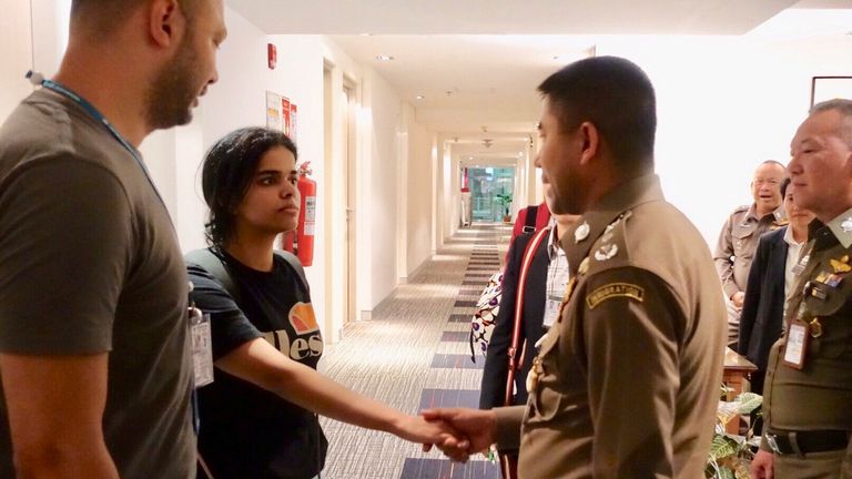 Saudi teen Rahaf Mohammed al-Qunun is greeted by Thai immigration authorities at a hotel inside Suvarnabhumi Airport in Bangkok