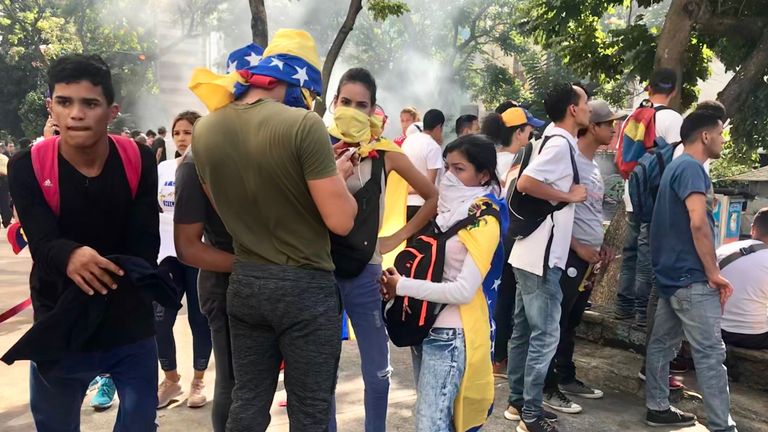 Venezuelans cover their noses and mouths as protests continue