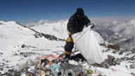 A Nepalese sherpa collecting garbage, left by climbers