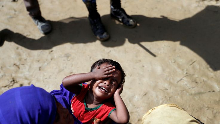 A Rohingya refugee child reacts as people queue for aid in a camp in Cox&#39;s Bazar, Bangladesh