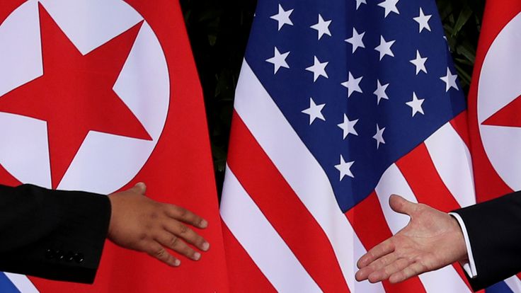 Donald Trump and Kim Jong Un prepare to shake hands