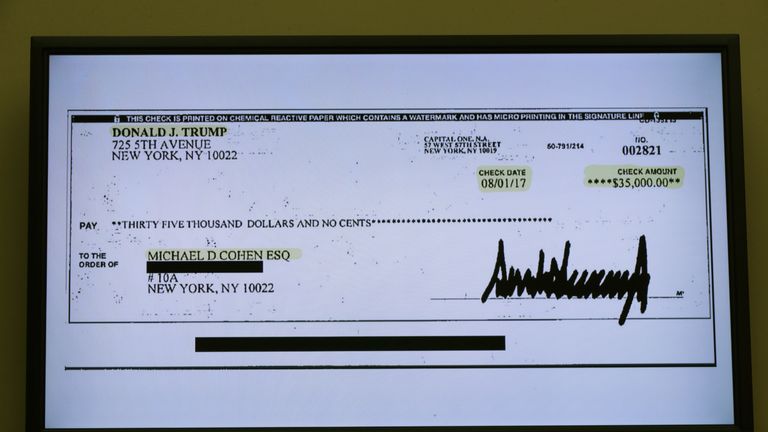 A copy of a cheque paid to Michael Cohen by President Trump is displayed as Michael Cohen, former attorney and fixer for President Donald Trump testifies before the House Oversight Committee on Capitol Hill February 27, 2019 in Washington, DC. Last year Cohen was sentenced to three years in prison and ordered to pay a $50,000 fine for tax evasion, making false statements to a financial institution, unlawful excessive campaign contributions and lying to Congress as pa