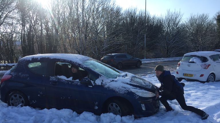 People work to free their cars trapped by heavy snow near the M3 in Basingstoke