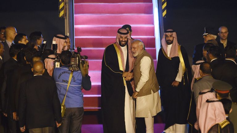 Mohammed bin Salman (L) shakes hands with Narendra Modi at the airport in New Delhi
