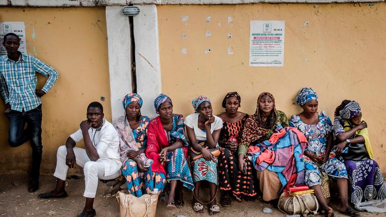 A group of women sit at the entrance of a polling station in Gombi