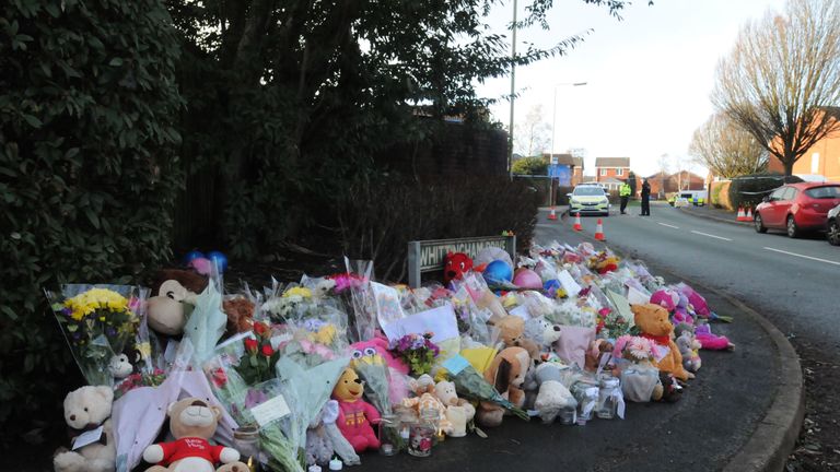 Flowers and stuffed animals left in tribute to the four children who died in the fire