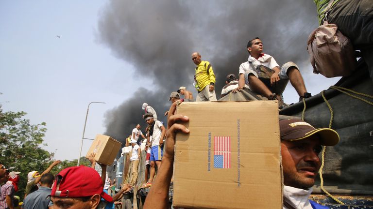 People rushed to get the aid off the burning truck on the Francisco de Paula Santander bridge