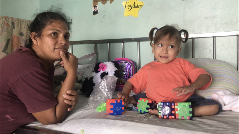 A mother and her young daughter wait for treatment