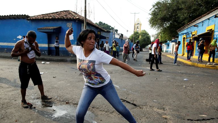 A woman throws an object at police in Urena 