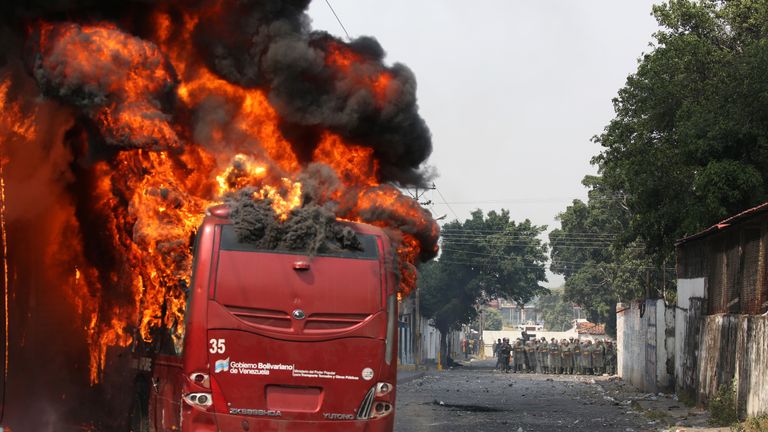 A bus was set on fire by demonstrators as security forces battled for control in Urena
