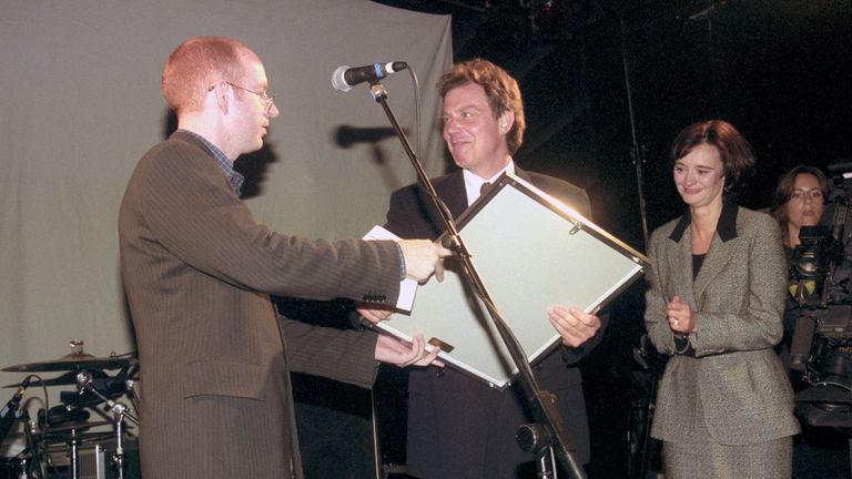 Cherie Booth looks on as Tony Blair receives a platinum disc of Oasis album What's The Story, Morning Glory from Alan McGee of Creation Records in Blackpool 1996