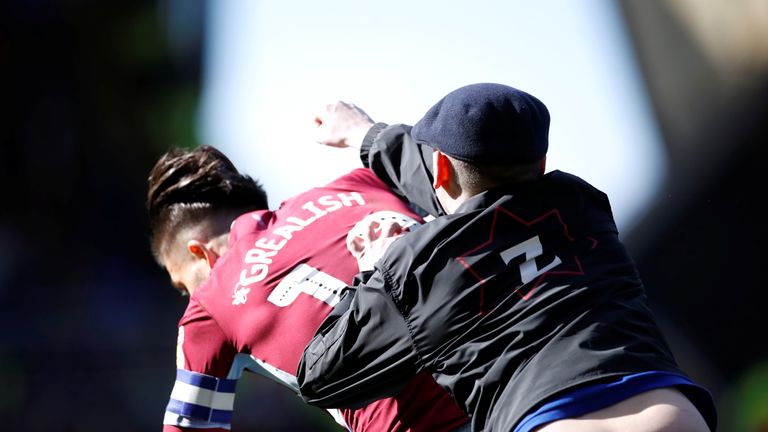 A fan invades the pitch and attacks Aston Villa&#39;s Jack Grealish during the match