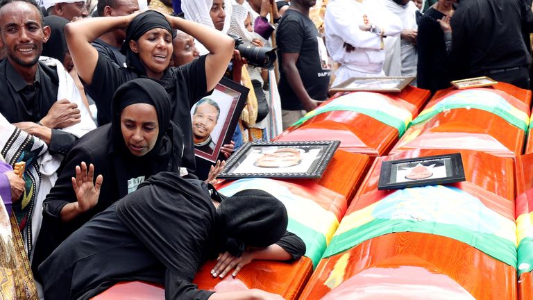 Women mourn next to the coffins of relatives who died in the Ethiopian Airlines crash