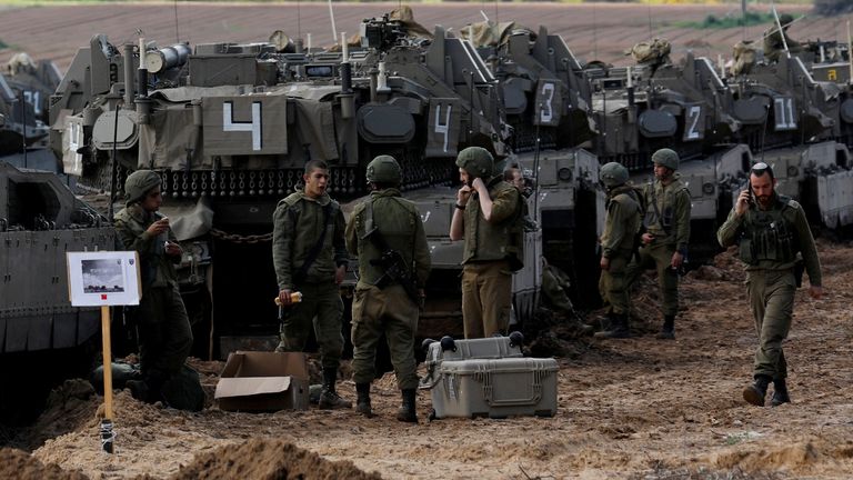 Israeli soldiers chat next to armoured personnel carrier's (APC) near the border with Gaza