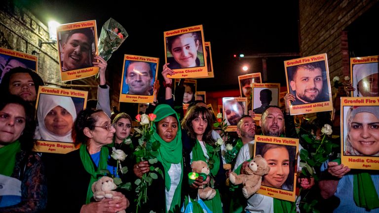 Families and friends who lost loved ones in the fire hold portraits of the victims in 2018