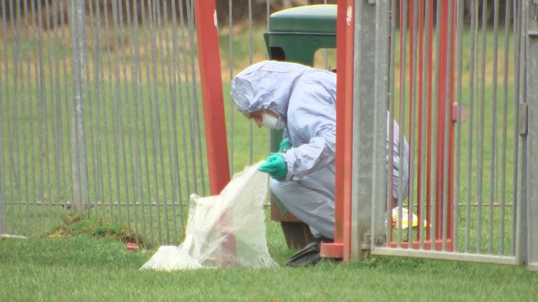 Forensic officers inspect the scene where a 17-year-old girl was stabbed to death