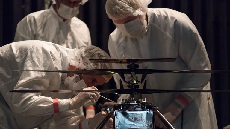 NASA's Mars Helicopter team attaching a thermal film enclosure to the fuselage of the flight model at NASA's Jet Propulsion Laboratory in Pasadena, California