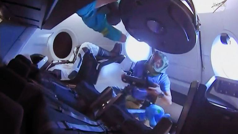 Expedition 58 crew members enter the SpaceX Crew Dragon for the first time. They are wearing protective gear to avoid breathing particulate matter that may shaken loose during launch. Pic: NASA
