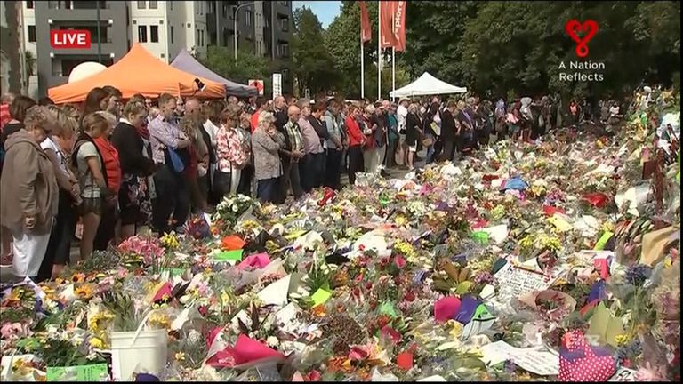 Mourners gather and leave flowers as a nation remembers the victims