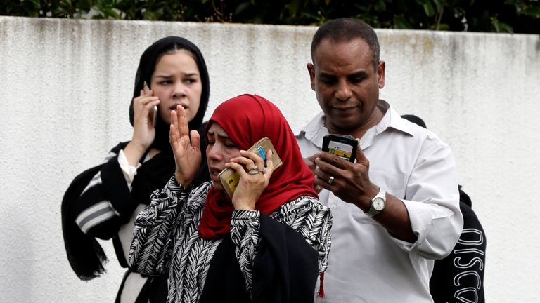 People wait outside a mosque in central Christchurch, New Zealand