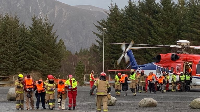 Stranded passengers that were rescued by helicopter from the cruise ship Viking Sky arrive on land
