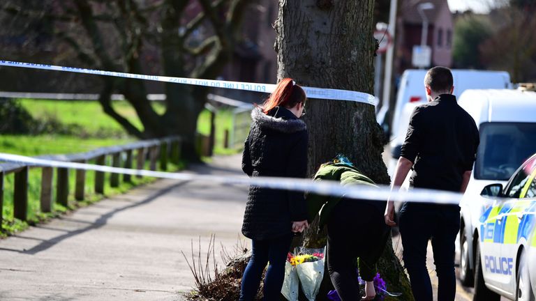 People place flowers near the scene of the stabbing