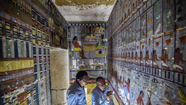 Experts examine markings on the wall of the tomb near Saqqara