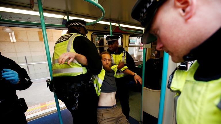 Police detain a protester as climate change activists demonstrate during the Extinction Rebellion protest, at Canary Wharf DLR station in London, Britain April 17, 2019. REUTERS/Henry Nicholls