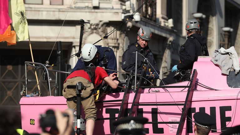 One of the last remaining Extinction Rebellion demonstrators attached to the boat, who glued himself to the mast, is detached and helped off the boat by police