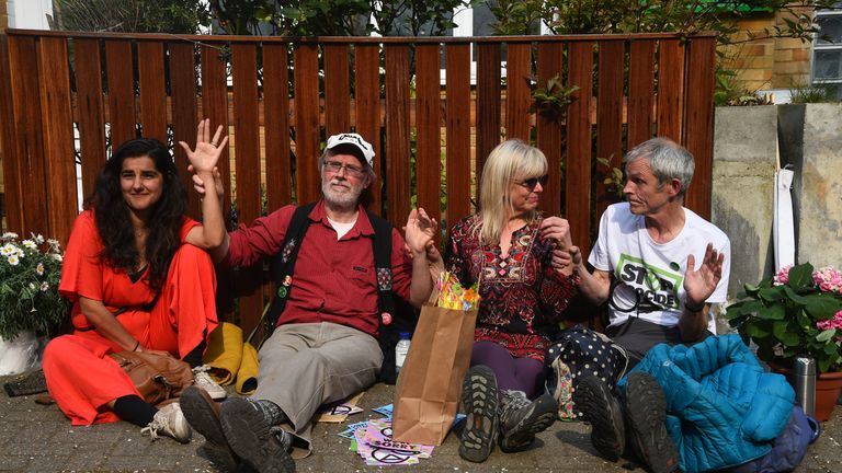 Climate activists who have glued themselves together sit outside Labour Party leader Jeremy Corbyn's house in north London.