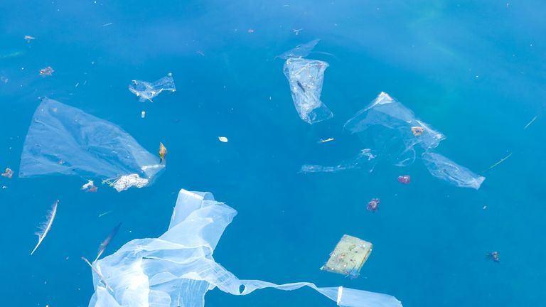 Plastic bags and debris floating in the sea - Stock image