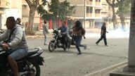 People flee after security attempt to drive them from the streets in Caracas 