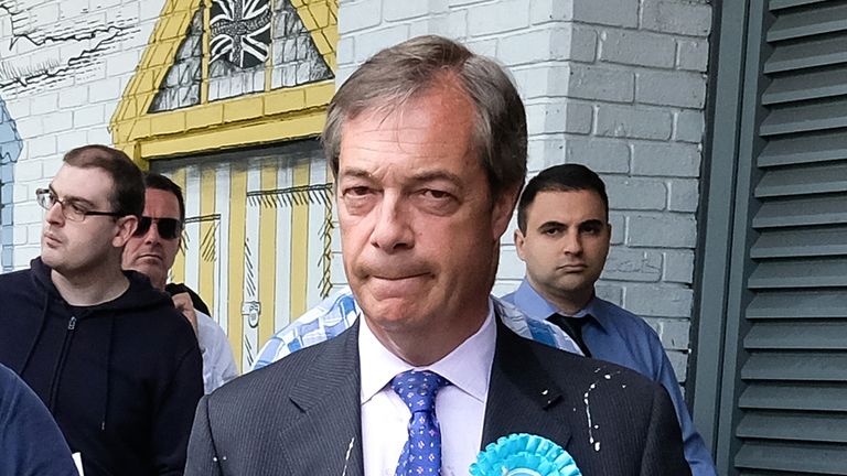 Nigel Farage is escorted to a car after having milkshake thrown over him
