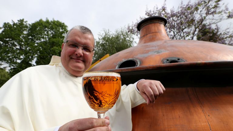 Norbertine Father Karel poses with a Grimbergen beer, symbolised by a phoenix, in the courtyard of the Belgian Abbey of Grimbergen before announcing that the monks will return to brewing after a break of two centuries, in Grimbergen, Belgium May 21, 2019. REUTERS/Yves Herman