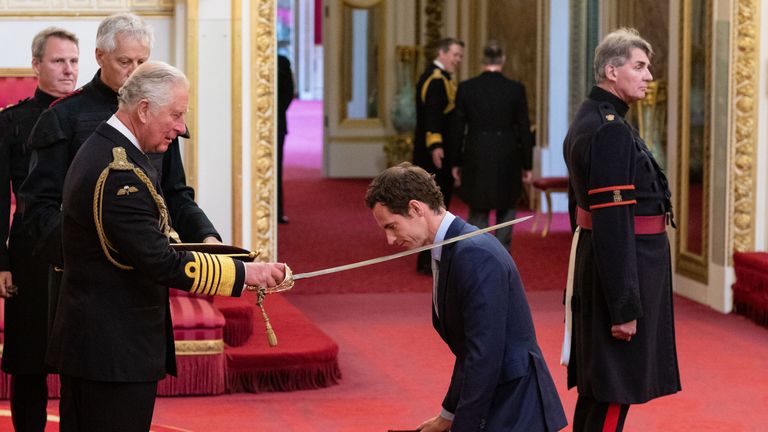 Andy MNurray kneels as he receives his knighthood from Prince Charles